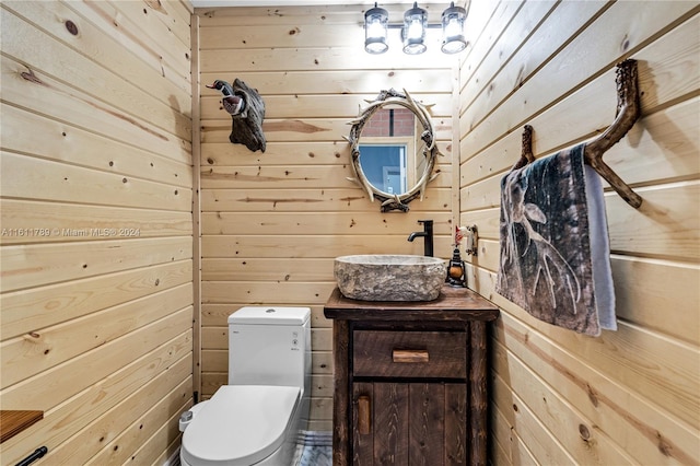 bathroom featuring wood walls, vanity, and toilet