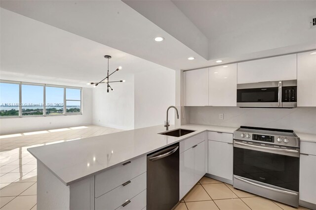 kitchen featuring sink, stainless steel appliances, kitchen peninsula, white cabinets, and light tile patterned floors