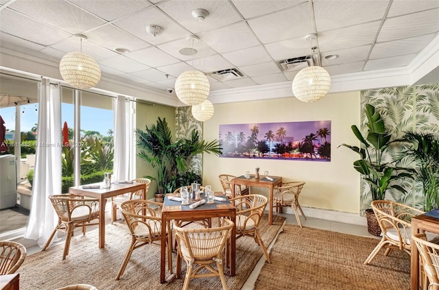 dining area with a paneled ceiling and ornamental molding