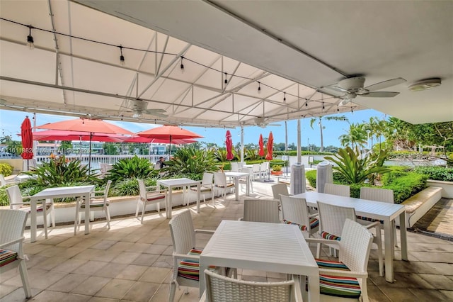 view of patio featuring a water view and ceiling fan