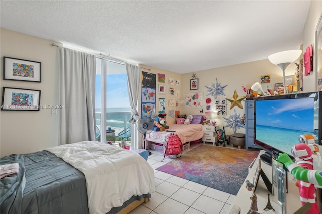 bedroom featuring a textured ceiling, light tile patterned flooring, and access to exterior