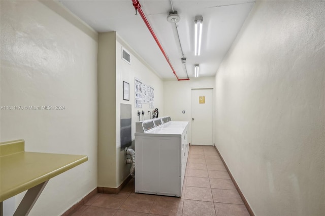 laundry room featuring light tile patterned floors and washing machine and dryer