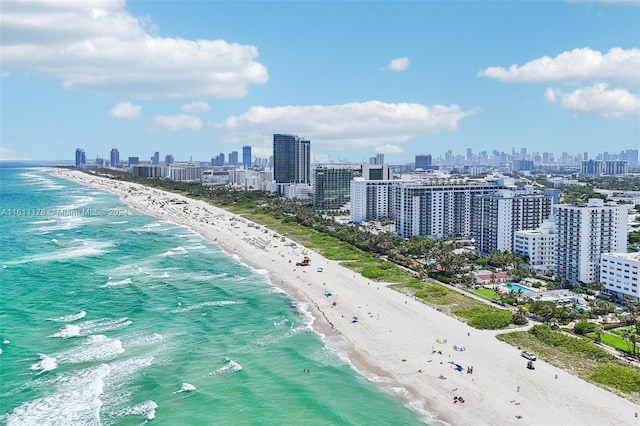 birds eye view of property featuring a water view and a beach view