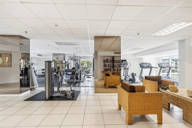 workout area with a drop ceiling and light tile patterned floors