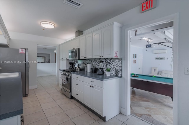 kitchen with stainless steel appliances, white cabinets, backsplash, pool table, and light tile floors