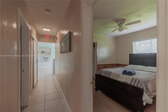 tiled bedroom with a textured ceiling and ceiling fan