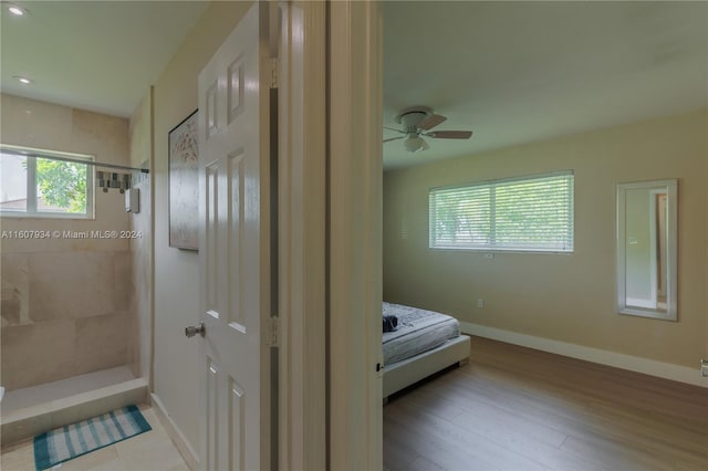 bathroom featuring a tile shower, hardwood / wood-style floors, and ceiling fan