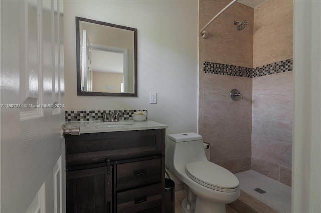 bathroom with tiled shower, toilet, and vanity