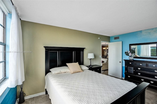 tiled bedroom featuring a textured ceiling