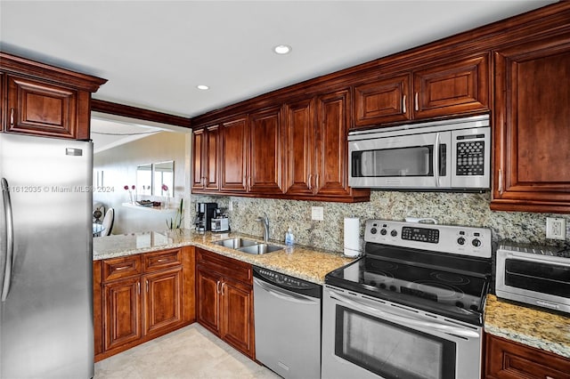 kitchen featuring light stone countertops, appliances with stainless steel finishes, backsplash, sink, and light tile floors