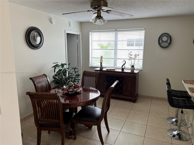 tiled dining area featuring a textured ceiling and ceiling fan