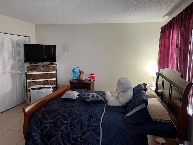 bedroom with light tile patterned flooring, a closet, and a textured ceiling