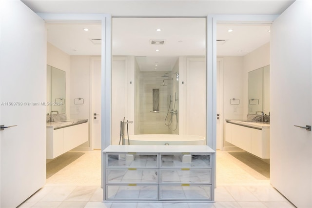 bathroom with tile patterned flooring, a tile shower, and vanity