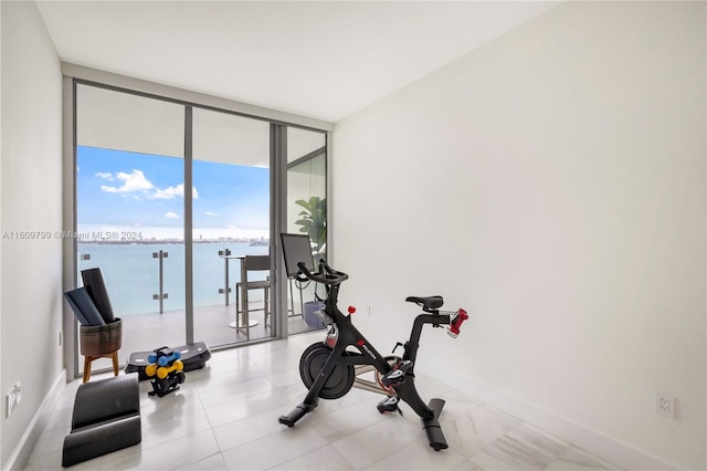 exercise area with a water view and a wall of windows