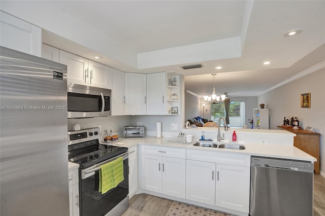 kitchen with light hardwood / wood-style floors, sink, kitchen peninsula, and stainless steel appliances