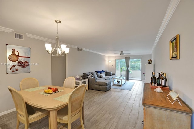 dining area featuring wood-type flooring, ceiling fan with notable chandelier, and crown molding