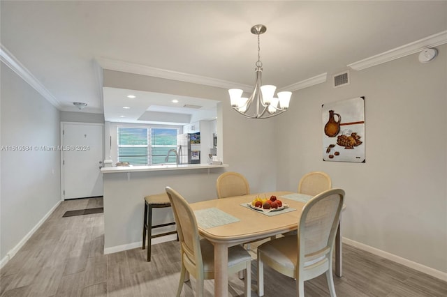 dining room with crown molding, a notable chandelier, light hardwood / wood-style floors, and a raised ceiling