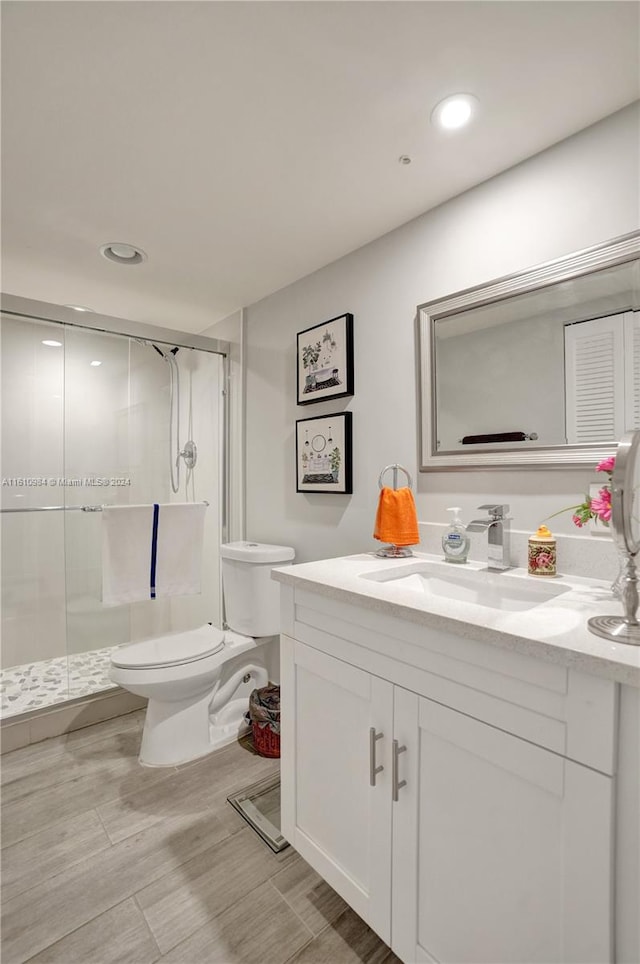 bathroom with vanity, toilet, tile patterned flooring, and an enclosed shower