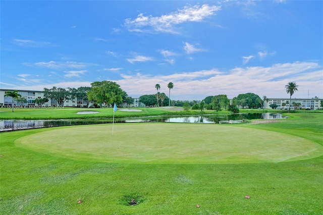 surrounding community with a water view and a lawn