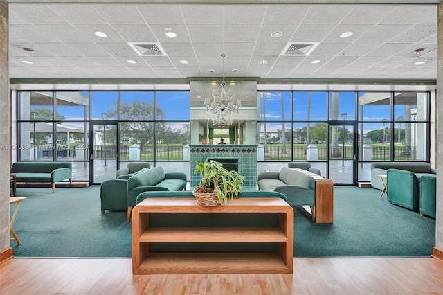 living room featuring wood-type flooring, floor to ceiling windows, and plenty of natural light