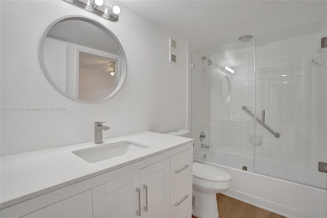 full bathroom featuring enclosed tub / shower combo, toilet, wood-type flooring, and vanity