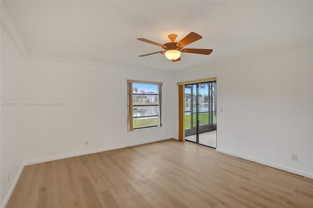 spare room featuring ceiling fan, crown molding, and light wood-type flooring