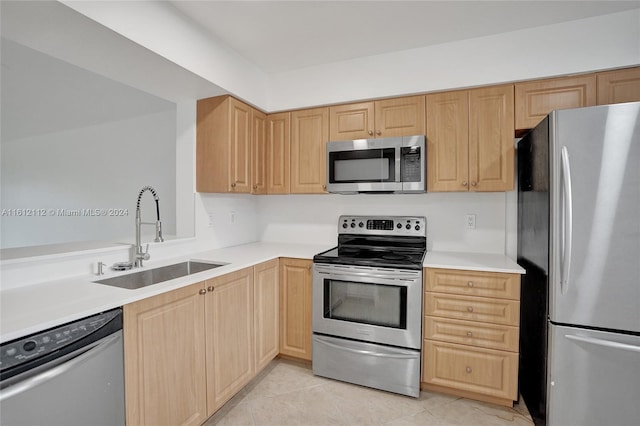 kitchen with light brown cabinetry, sink, light tile patterned floors, and appliances with stainless steel finishes