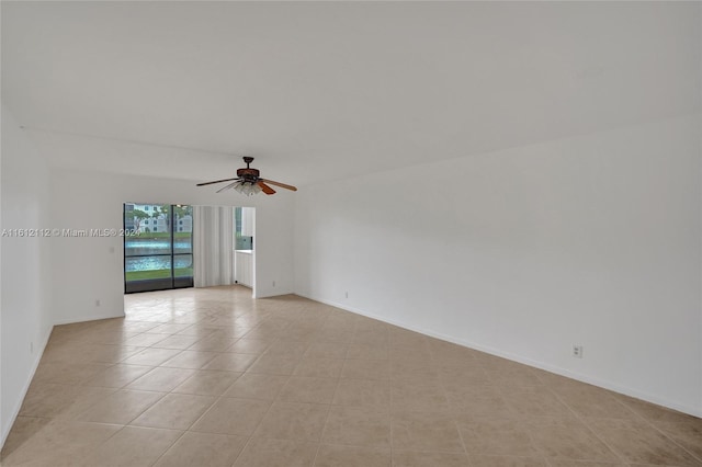 tiled spare room with ceiling fan