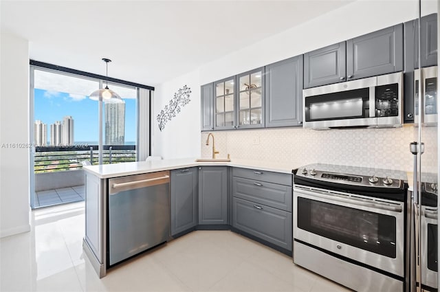 kitchen featuring decorative light fixtures, stainless steel appliances, light tile flooring, and tasteful backsplash