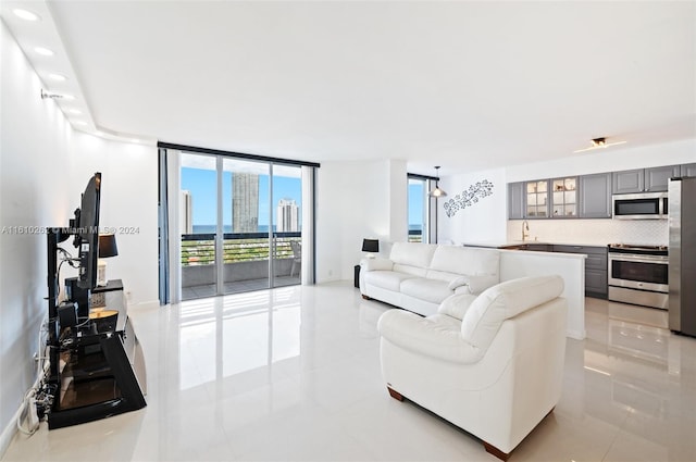 tiled living room with sink and floor to ceiling windows