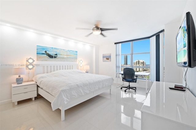 tiled bedroom with ceiling fan and a wall of windows