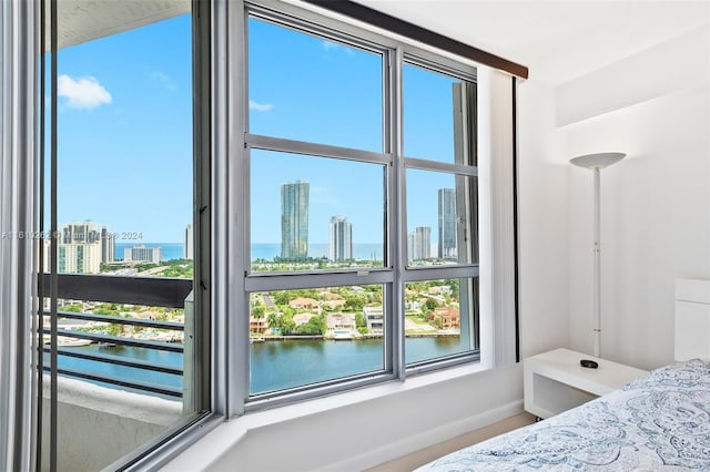 bedroom with multiple windows and a water view