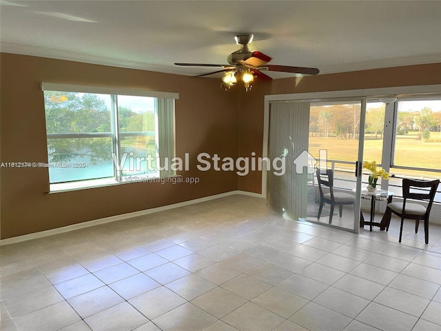 tiled empty room with baseboards, ornamental molding, and a ceiling fan