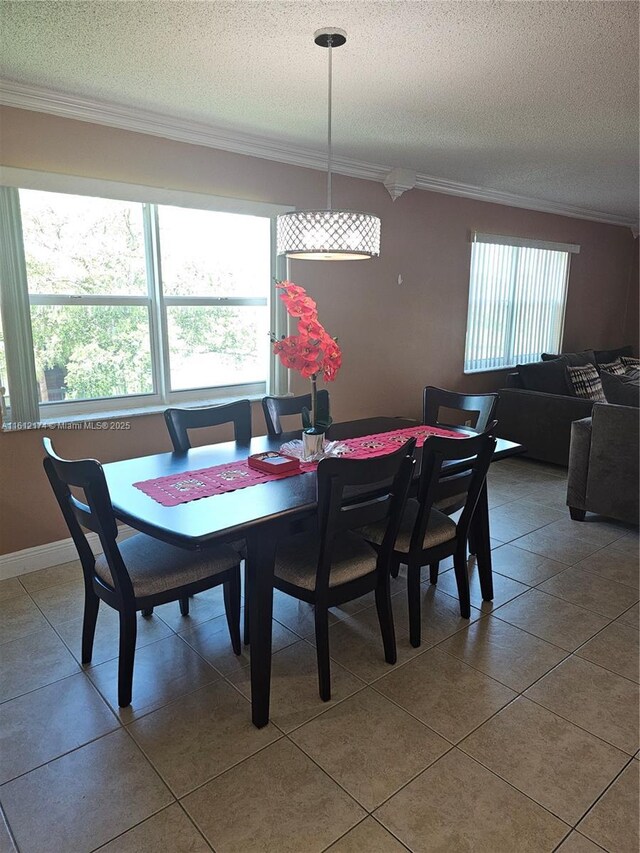 tiled dining area with crown molding and a textured ceiling