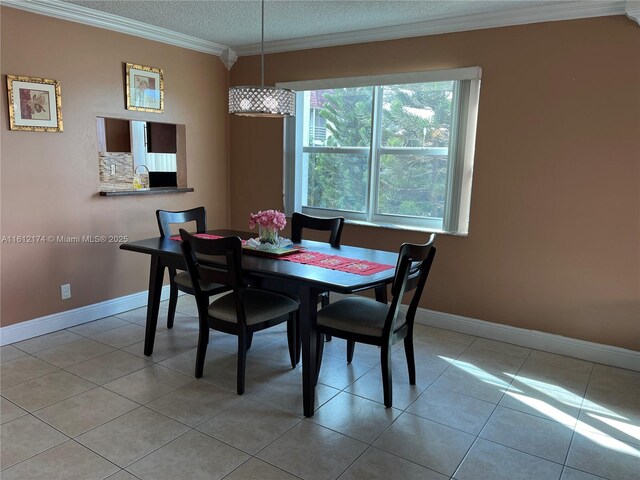 tiled dining area with a textured ceiling and ornamental molding