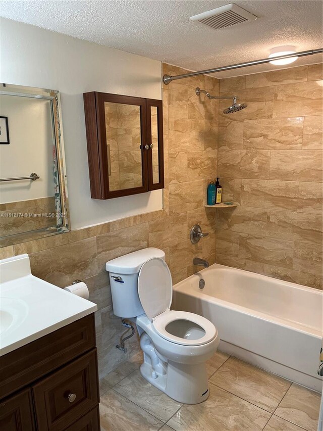 full bathroom with vanity, tile patterned floors, shower / bath combination with curtain, a textured ceiling, and tile walls