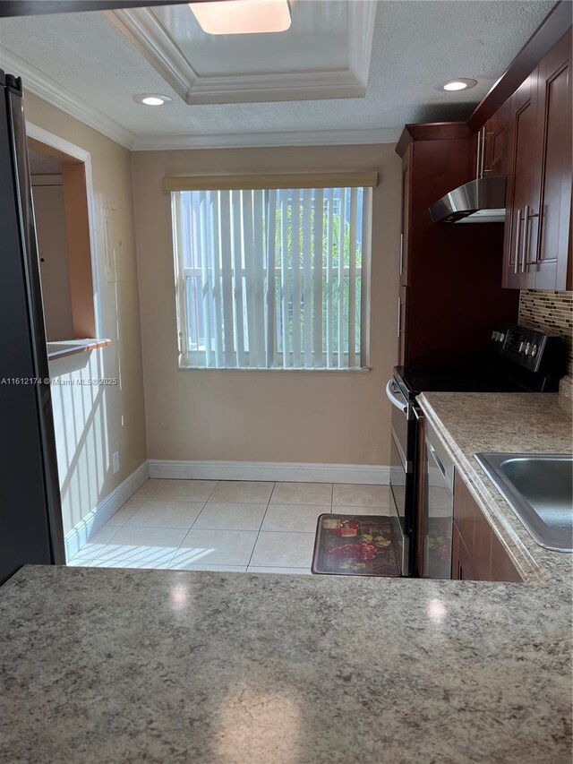 kitchen featuring decorative backsplash, light tile patterned floors, stainless steel appliances, and sink