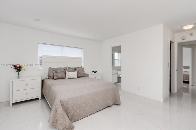 bedroom with ensuite bath and light tile flooring