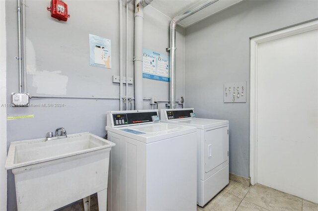 laundry room featuring sink, washing machine and clothes dryer, washer hookup, and light tile floors