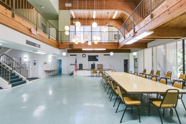 dining room featuring wooden ceiling and a high ceiling