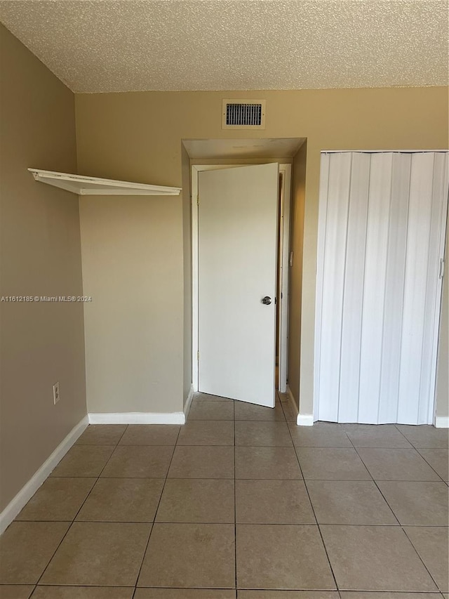 interior space featuring tile patterned floors and a textured ceiling