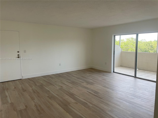 spare room featuring light hardwood / wood-style flooring and a textured ceiling