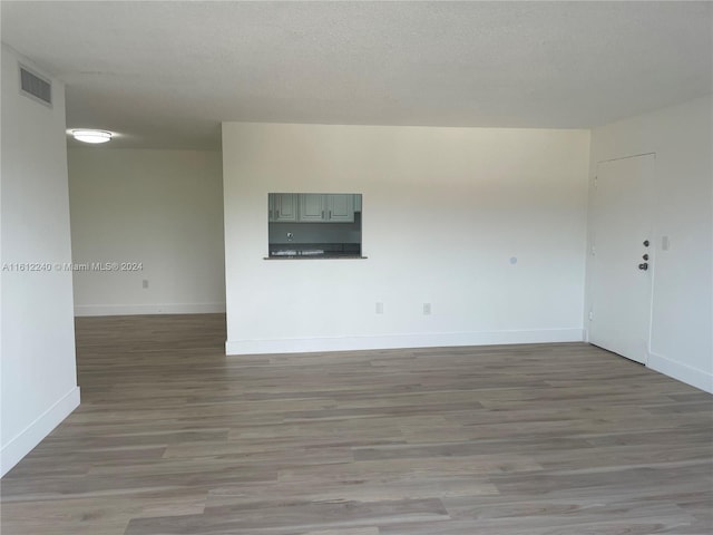 spare room featuring wood-type flooring and a textured ceiling