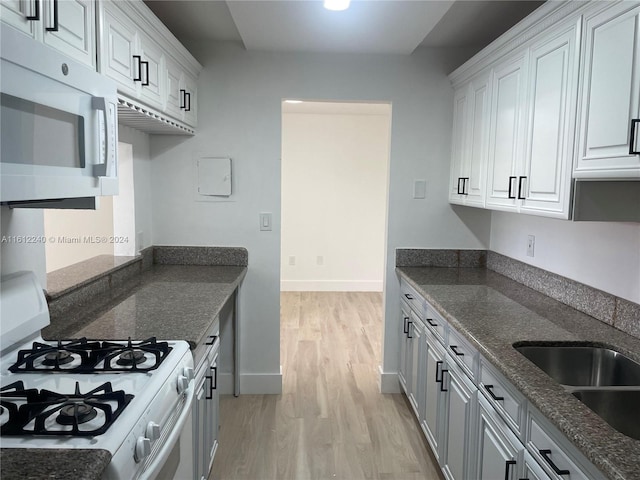 kitchen with white cabinetry, white gas stove, and light wood-type flooring