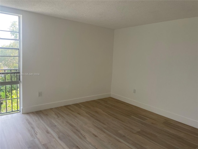 spare room with hardwood / wood-style floors and a textured ceiling