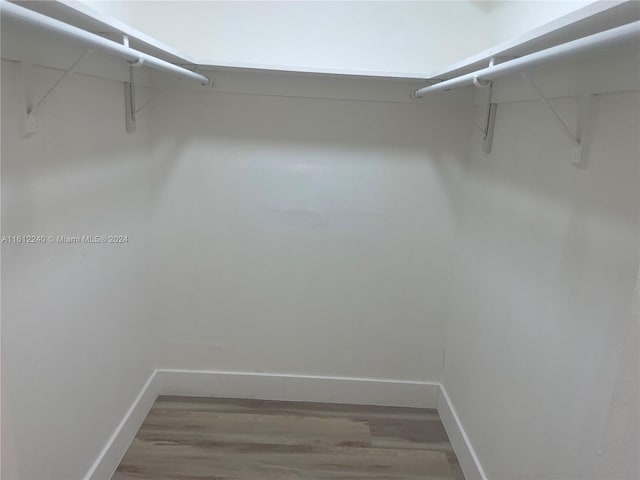 walk in closet with hardwood / wood-style flooring