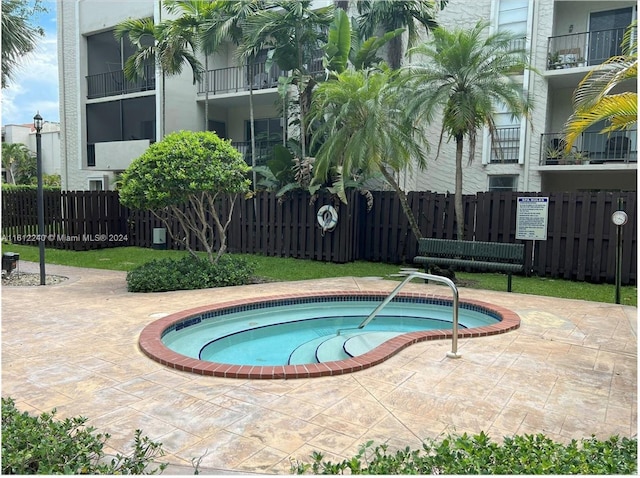 view of pool featuring a hot tub and a patio area