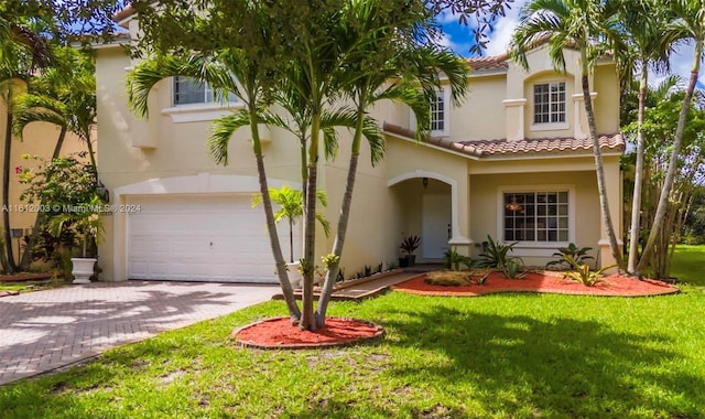 mediterranean / spanish-style house featuring a garage and a front yard