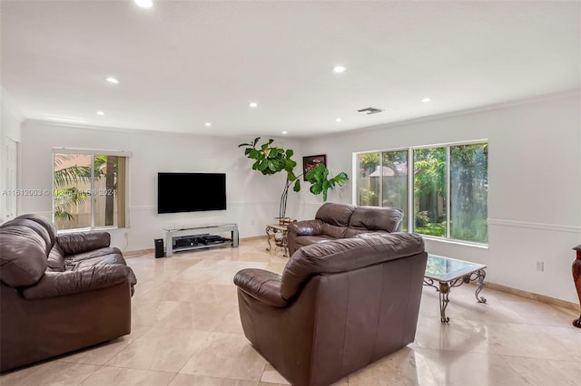 living room featuring light tile patterned floors and ornamental molding