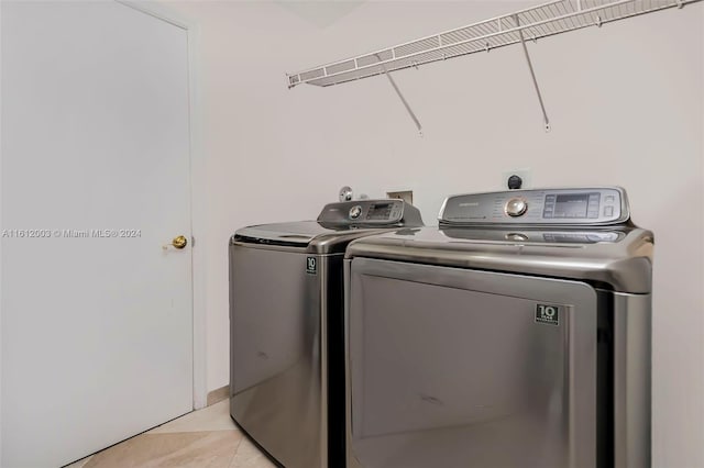 clothes washing area featuring washer and dryer and light tile patterned floors